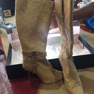 Beautiful fur boots with a chain around them.